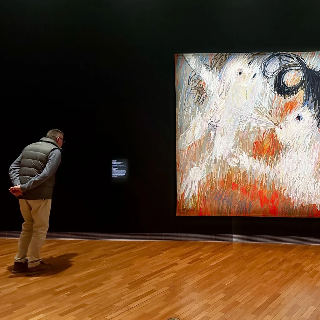 A visitor viewing an Arthur Boyd tapestry in the National Gallery of Australia in Canberra